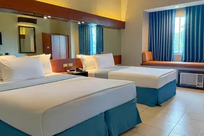 a hotel room with two beds and a window at Microtel by Wyndham Eagle Ridge in General Trias