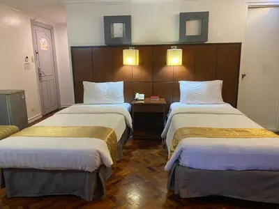 a hotel room with two beds in a room at Comfy Inn Manila-Kalaw in Manila