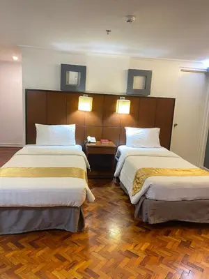 two beds in a hotel room with two lamps at Comfy Inn Manila-Kalaw in Manila