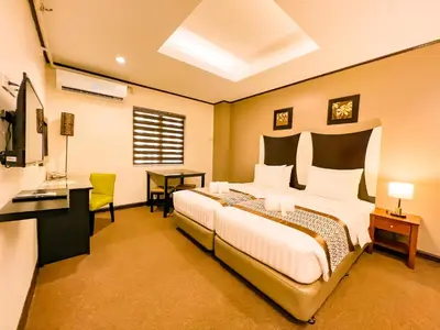 a bedroom with a large bed and a desk at Casa Bocobo Hotel in Manila