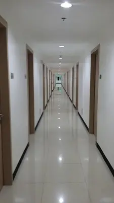 an empty hallway of a building with white floors at Light Residences 1BR Apartment Balcony in Manila