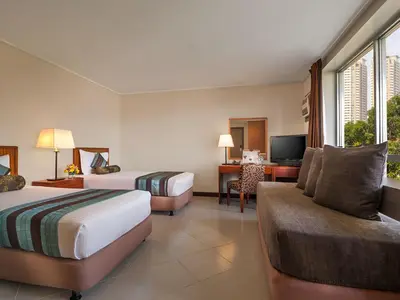 a hotel room with two beds and a couch at Hotel Kimberly Manila in Manila