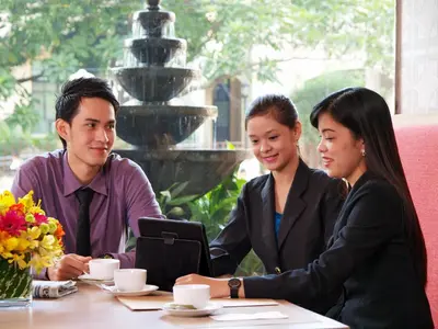 a group of people sitting at a table with a laptop at Hotel Kimberly Manila in Manila
