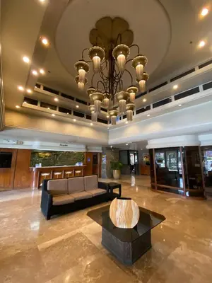 a living room with a couch and a chandelier at Copacabana Apartment Hotel in Manila