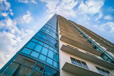a tall building with glass windows against a blue sky at Astoria Plaza in Manila