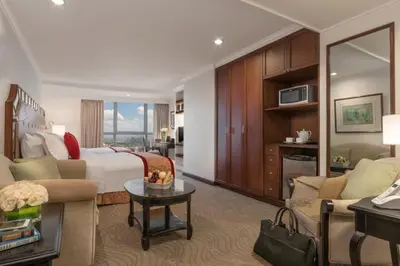 a hotel room with a bed and a living room at Discovery Suites Manila, Philippines in Manila
