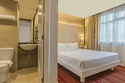 a hotel room with a bed and a bathroom at St Giles Hotel Makati in Manila