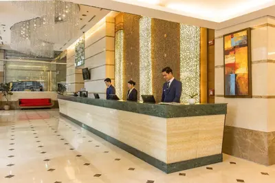 a group of people standing at a counter in a lobby at St Giles Hotel Makati in Manila