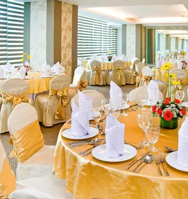 a dining room with white tables and white chairs at St Giles Hotel Makati in Manila