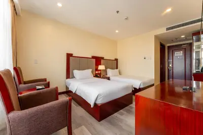 a hotel room with two beds and a desk at Swiss-Belhotel Blulane in Manila