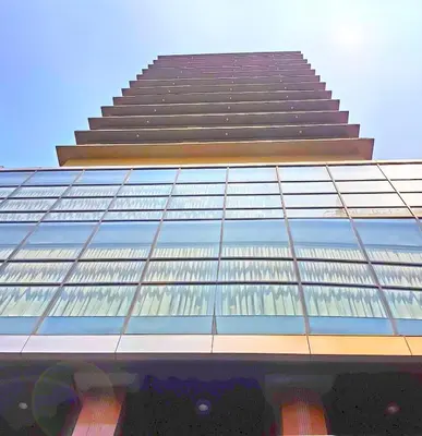 a tall building with a lot of glass windows at Swiss-Belhotel Blulane in Manila