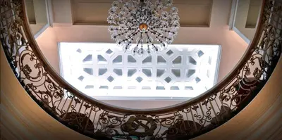 a circular staircase with a chandelier and a window at Networld Hotel Spa and Casino in Manila