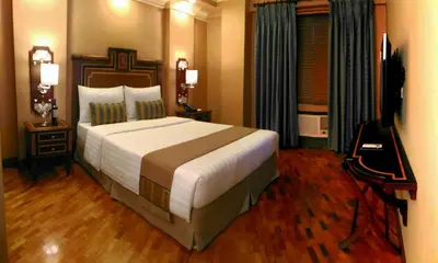 a bedroom with a large bed and a television at Herald Suites Polaris in Manila