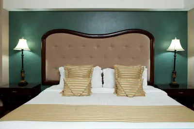 a bedroom with a large bed with two lamps at Hotel Celeste Makati in Manila