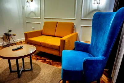 a living room with a couch and a chair and a table at Parque España Residence Hotel in Manila