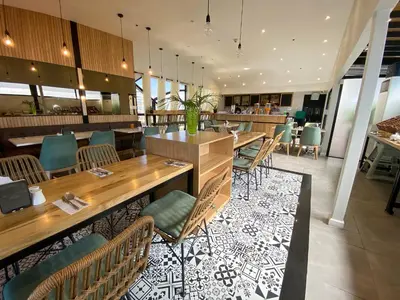 a restaurant with wooden tables and chairs and a bar at Parque España Residence Hotel in Manila
