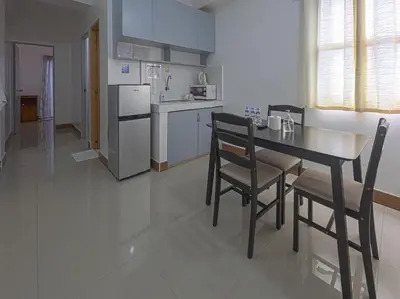 a kitchen with a table and chairs and a refrigerator at Alicia Apartment in Manila
