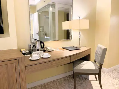 a desk in a room with a mirror and a chair at Hotel Benilde Maison De La Salle in Manila