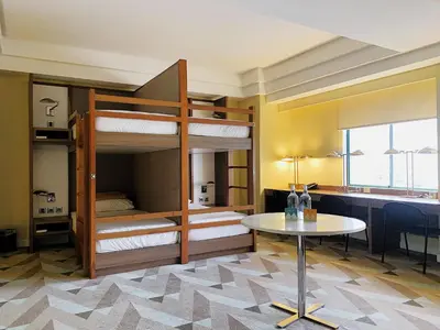 a room with bunk beds and a table and a desk at Hotel Benilde Maison De La Salle in Manila