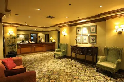 a hotel lobby with a reception desk and chairs at Herald Suites in Manila