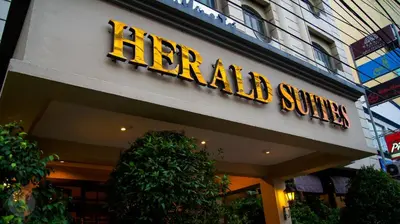 a hotel sign on the side of a building at Herald Suites in Manila
