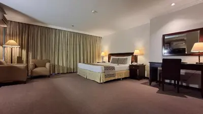 a large hotel room with a bed and a desk at Herald Suites Solana in Manila