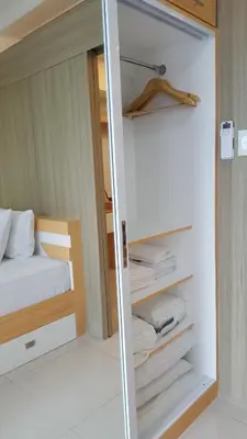 a bedroom with a bed and a glass door at Breeze Residences by CS Luxe in Manila