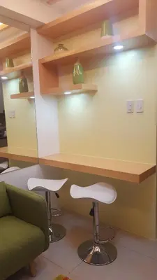 a waiting room with a counter and two stools at Breeze Residences by CS Luxe in Manila