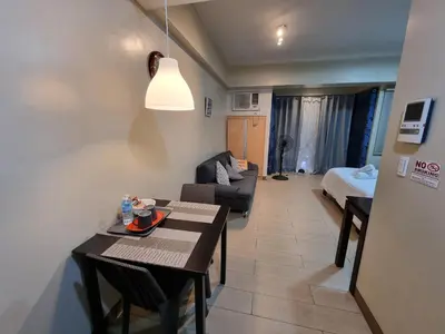 a small living room with a table and a couch at Palm Tree Condos near MNL Airport Terminal 3 by ELR in Manila