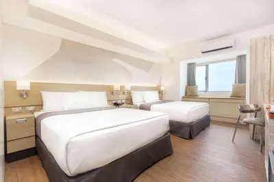 a hotel room with two beds and a desk at TRYP by Wyndham Mall of Asia Manila in Manila