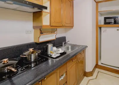 a kitchen with a sink and a stove top oven at Richmonde Hotel Ortigas, Manila in Manila