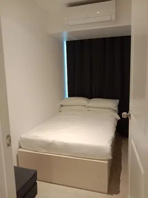 a small white bed in a room with a window at Azure Residences by Van Florendo in Manila