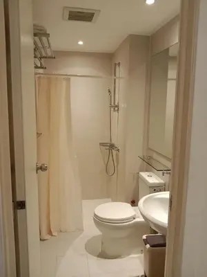 a bathroom with a toilet and a shower and a sink at Azure Residences by Van Florendo in Manila