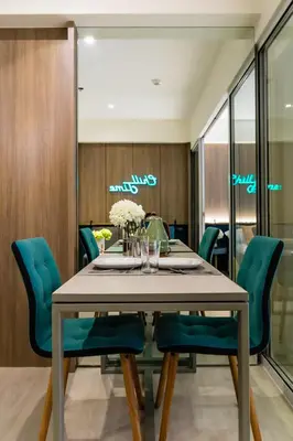 a dining room with a table and blue chairs at Azure Urban Beach Resort Manila by Radlett in Manila