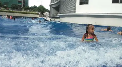 a little girl in a wave pool at a water park at Joanne Sweet Home in Manila