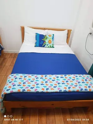a bed with a blue blanket on top of it at MJ Home in Manila