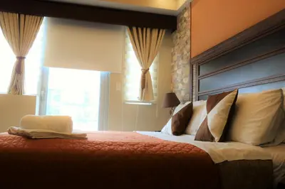 a bedroom with a large bed and a window at One Palm Tree Villas MANILA in Manila