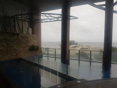 a swimming pool with a view of the ocean from a building at Eton Baypark in Manila