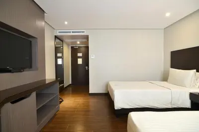 a hotel room with two beds and a flat screen tv at Pearl Garden Hotel in Manila