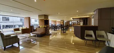 a lobby with chairs and a bar in a building at Pearl Garden Hotel in Manila