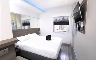 a bedroom with a bed with a laptop on it at Red Planet Manila Binondo in Manila