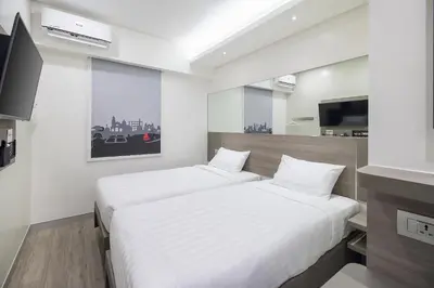 a bedroom with two beds and a television in it at Red Planet Manila Bay in Manila