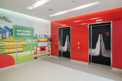 a red hallway with two doors and a sign on the wall at Red Planet Manila Bay in Manila