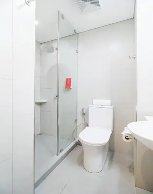 a white bathroom with a toilet and a shower at Red Planet Manila Bay in Manila