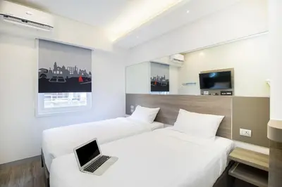 two beds in a hotel room with a laptop on the bed at Red Planet Manila Bay in Manila