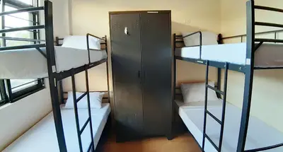 a room with three bunk beds and a door at Monchere Dormitory in Manila