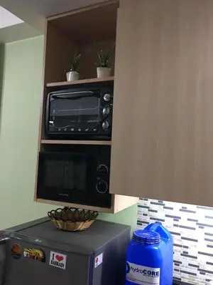 a microwave on top of a refrigerator in a kitchen at SMDC Light Residences Condominium in Manila