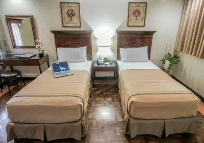 a hotel room with two beds with a laptop on it at Fersal Hotel - P. Tuazon Cubao in Manila