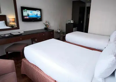 a hotel room with two beds and a television at Fersal Hotel Neptune Makati in Manila