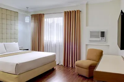 a hotel room with a bed and a chair at Rothman Hotel in Manila